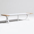 Extendable wooden table in white and light brown with a modern design, viewed from a low angle, perfect for dining or living spaces.
